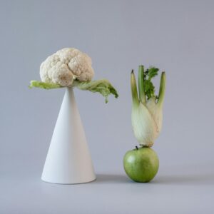 Minimalist presentation of cauliflower and fennel creatively balanced with a green apple.